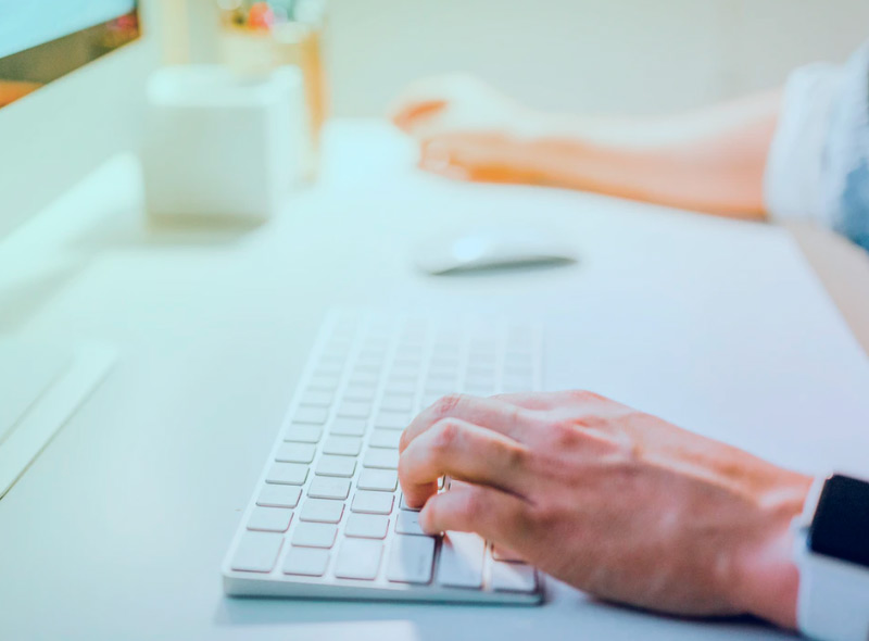 Programmer's hands typing on black keyboard