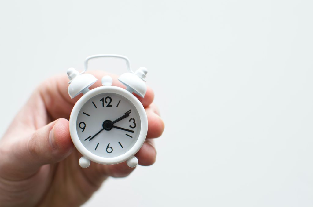 a man is holding clocks