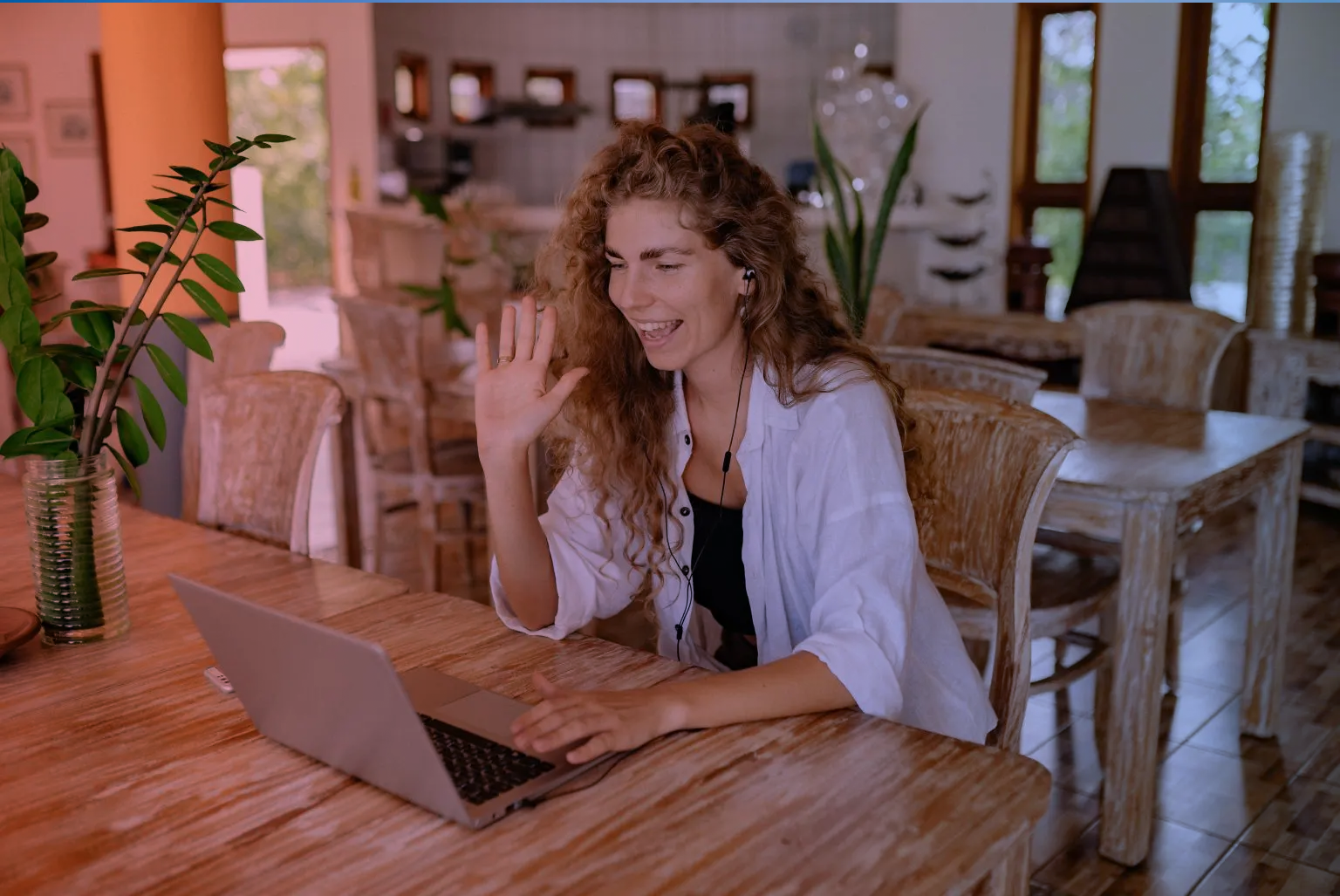A women is watching at the screen and waving her hand