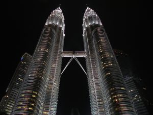 Kuala Lumpur skyline at night, showing the Petronas Twin Towers connected by a skybridge.