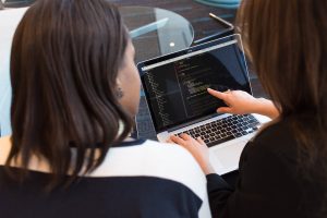 Developers, with code on their screens, working together